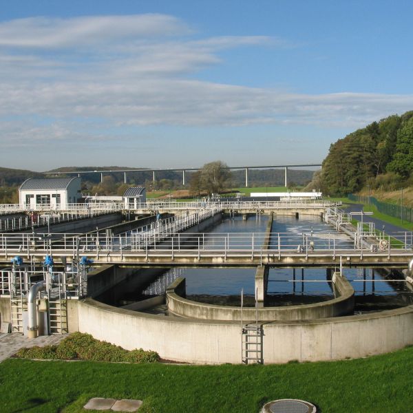 Belebungsbecken mit Brücke umgeben von Rasen