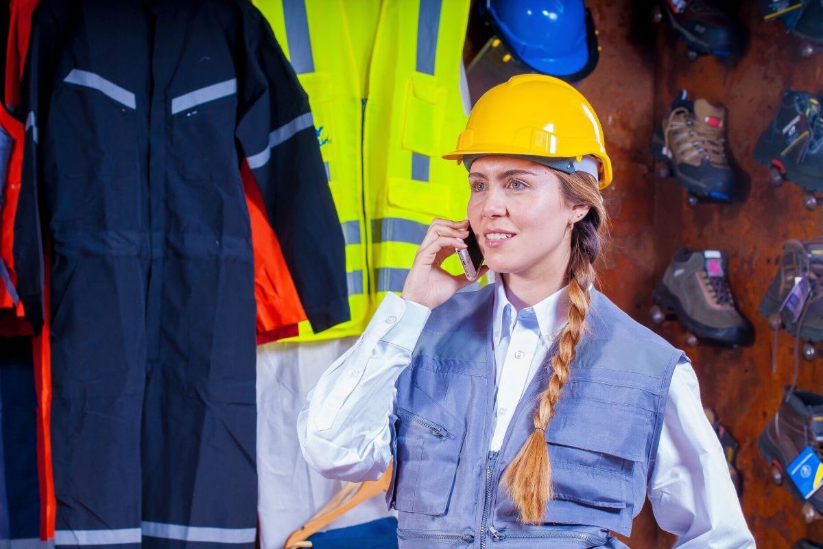 junge Frau mit Schutzhelm telefoniert