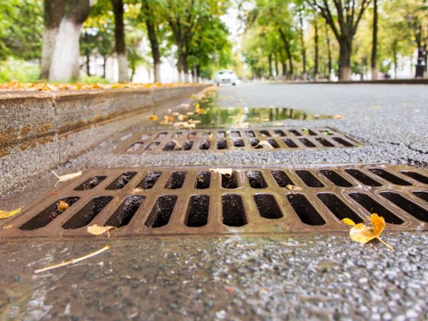 Strasse mit Kanalabfluss im Vordergrund